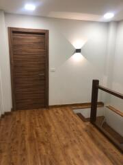 Modern hallway with wooden flooring and staircase