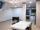 Dining area with chandelier and adjacent kitchen