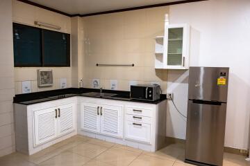 Modern kitchen with white cabinets and black countertops