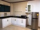 Modern kitchen with white cabinets and black countertops