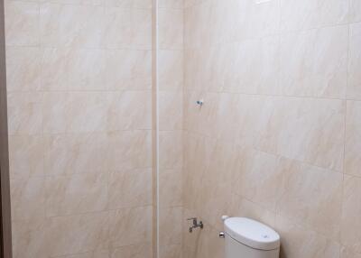 Tile bathroom with toilet, sink, and ventilation fan