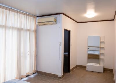 Bedroom with large window, air conditioning, and floor tiles