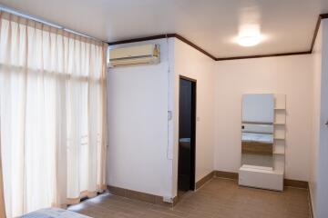 Bedroom with large window, air conditioning, and floor tiles