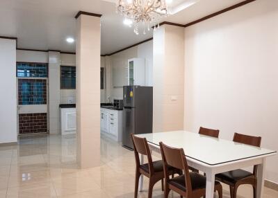 Kitchen and dining area with white cabinets and a glass dining table