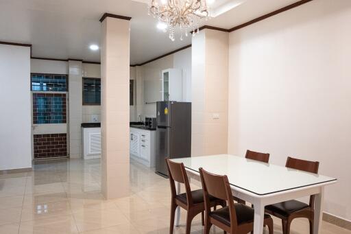 Kitchen and dining area with white cabinets and a glass dining table