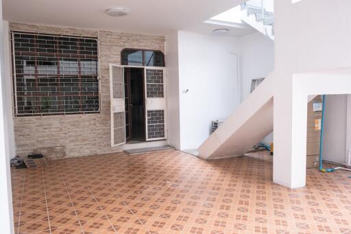 Covered entrance area with tilled floor and stairway