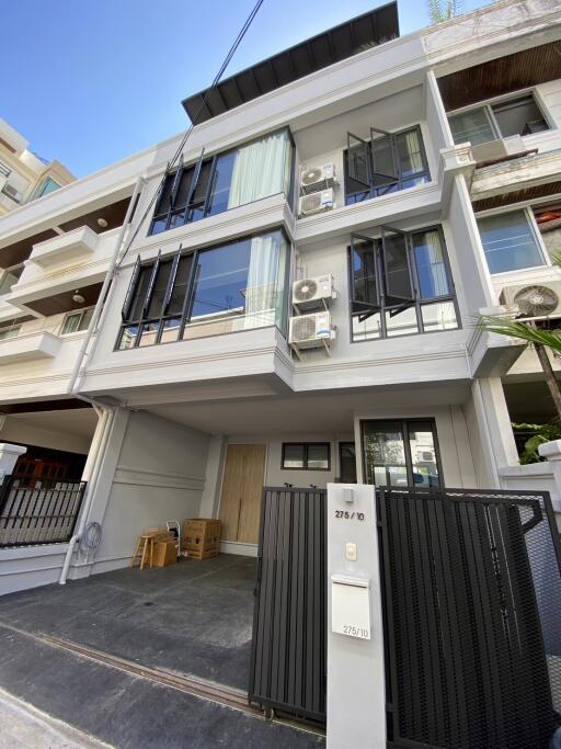 Modern multi-story residential building with balconies and air conditioning units