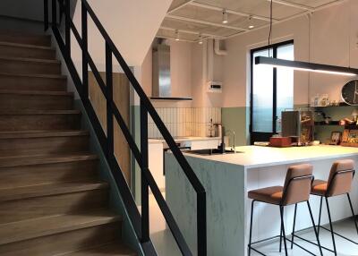 Modern kitchen with breakfast bar and staircase