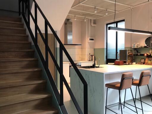 Modern kitchen with breakfast bar and staircase