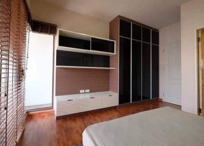 Modern bedroom with wood flooring and built-in shelves