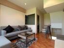 Modern living room with sofa, glass coffee table, and wooden flooring