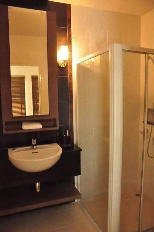 Modern bathroom with sink, mirror, and glass shower