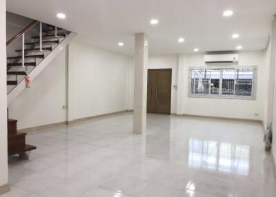 spacious living room with stairs and large window