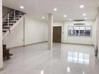 spacious living room with stairs and large window