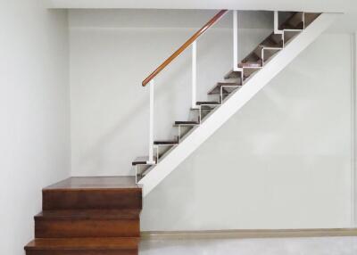 Modern staircase with wooden steps and white railing