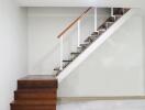 Modern staircase with wooden steps and white railing