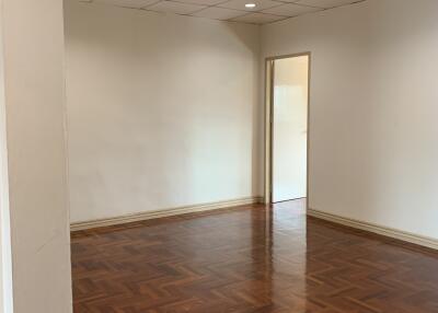 Spacious living room with wooden parquet flooring and recessed lighting