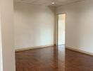 Spacious living room with wooden parquet flooring and recessed lighting