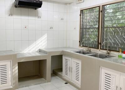 Modern kitchen with white tiled backsplash and dual sinks