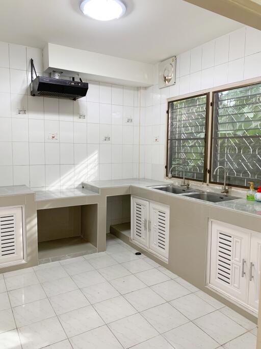 Modern kitchen with white tiled backsplash and dual sinks