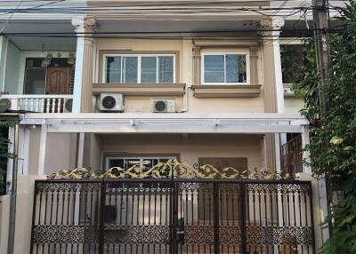 Front view of a two-story house with decorative metal front gate