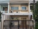 Front view of a two-story house with decorative metal front gate