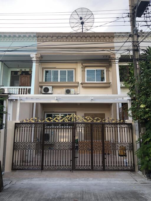 Front view of a two-story house with decorative metal front gate