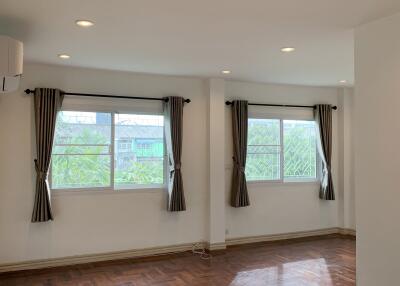 Spacious living room with large windows and wooden flooring