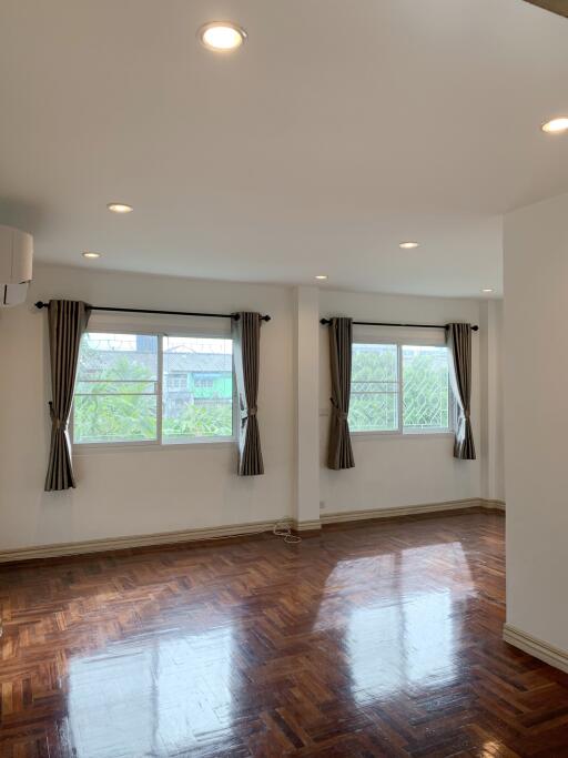 Spacious living room with large windows and wooden flooring