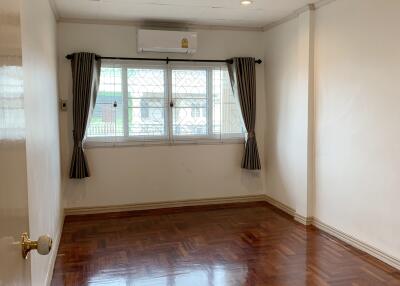 Empty bedroom with large window and wooden floor