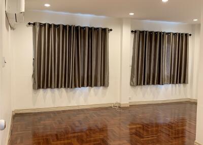 Spacious living room with wooden flooring and large windows