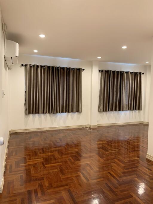 Spacious living room with wooden flooring and large windows