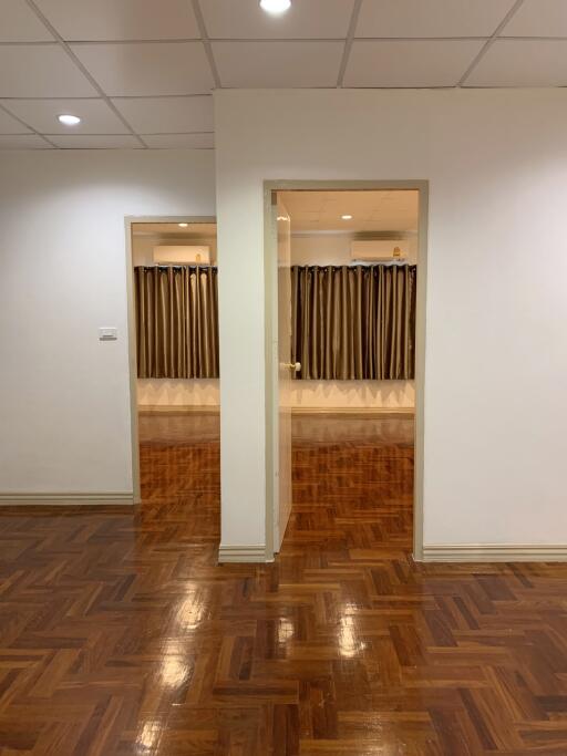 Spacious living area with hardwood flooring and recessed lighting