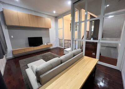 Modern living room with wooden flooring and mounted TV