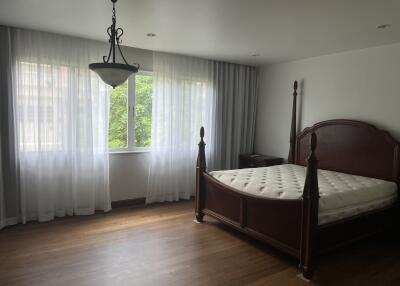 Spacious bedroom with hardwood flooring and large windows