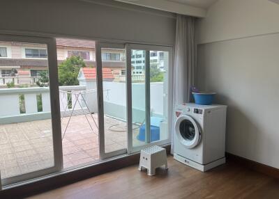 Utility room with washing machine and access to outdoor balcony