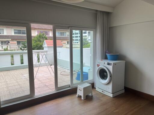 Utility room with washing machine and access to outdoor balcony