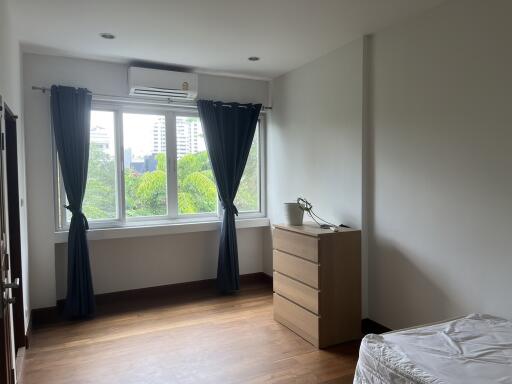 Bright bedroom with large windows and wooden flooring