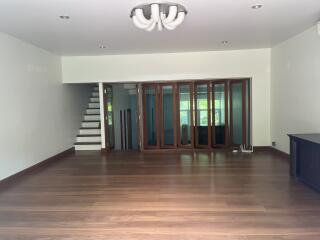 Spacious living room with wooden flooring and large windows