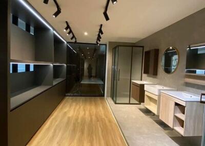 Modern bathroom with track lighting, wooden floor, and large mirrors