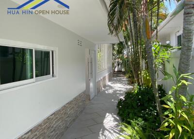 Side pathway with greenery and windows at Hua Hin Open House