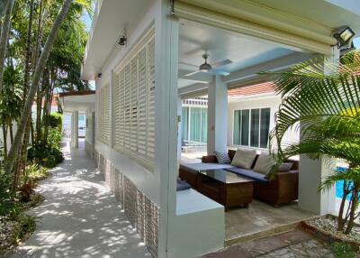 Covered outdoor lounge area with sofa and ceiling fan