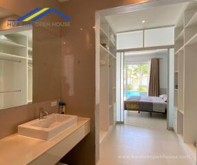 Modern bathroom with vanity and adjacent bedroom with pool view