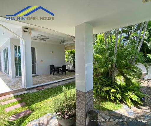 Covered patio with dining area and garden view