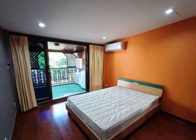 Bedroom with orange accent wall and access to balcony