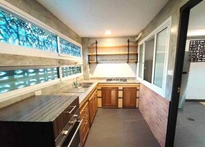 Modern kitchen with ample natural light and wooden cabinetry