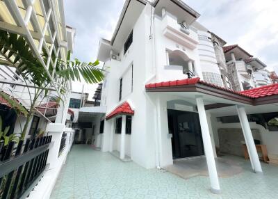 Exterior view of a white multi-story house with a patio