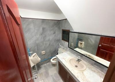 A bathroom with a marble sink, toilet, and urinal