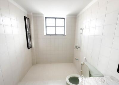 Spacious bathroom with tiled walls and marble countertop