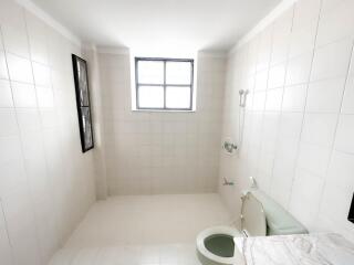 Spacious bathroom with tiled walls and marble countertop